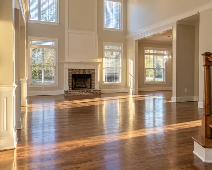 An empty living room in a resale home with clean floors and dusted baseboards
